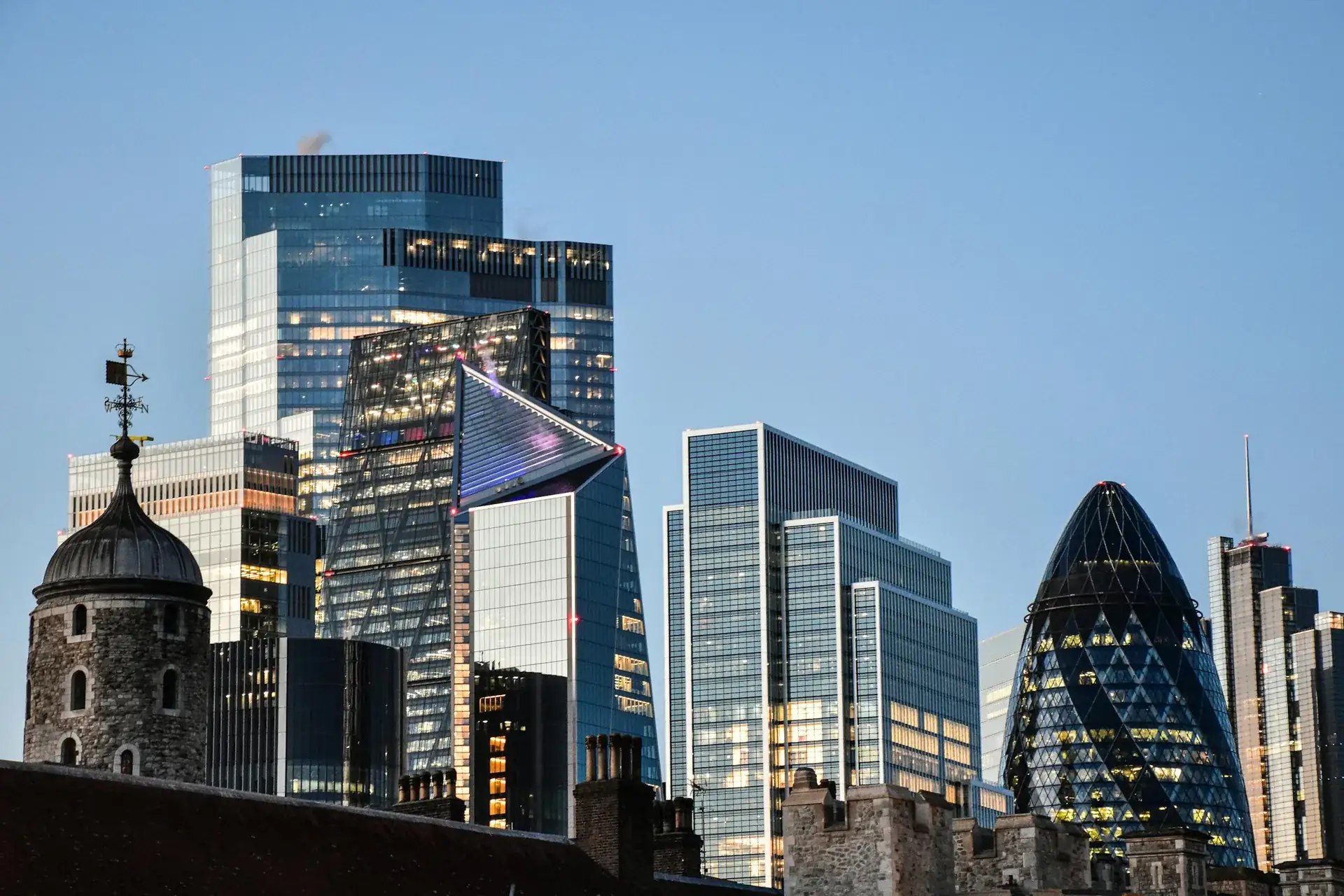 The City of London skyline at golden hour, viewed across the Tower of London.